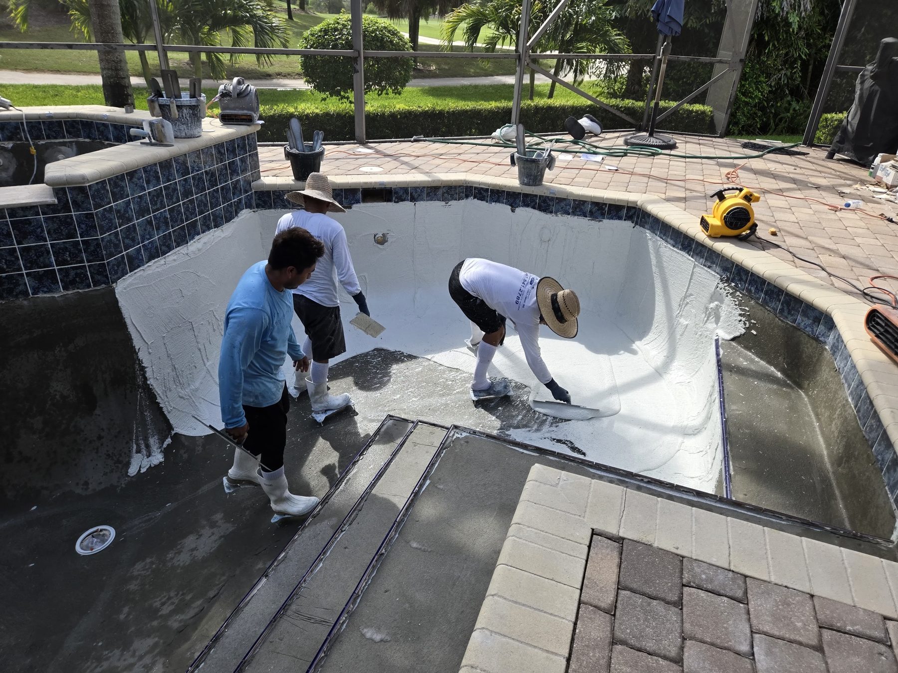 Labounty Pools crew applying new pool surface finish